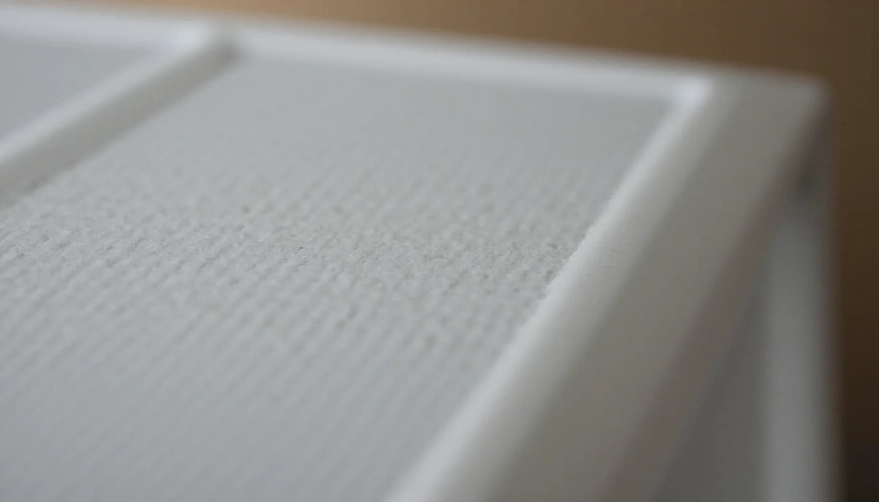 white pleated filter material with fine ridged texture and white frame edges