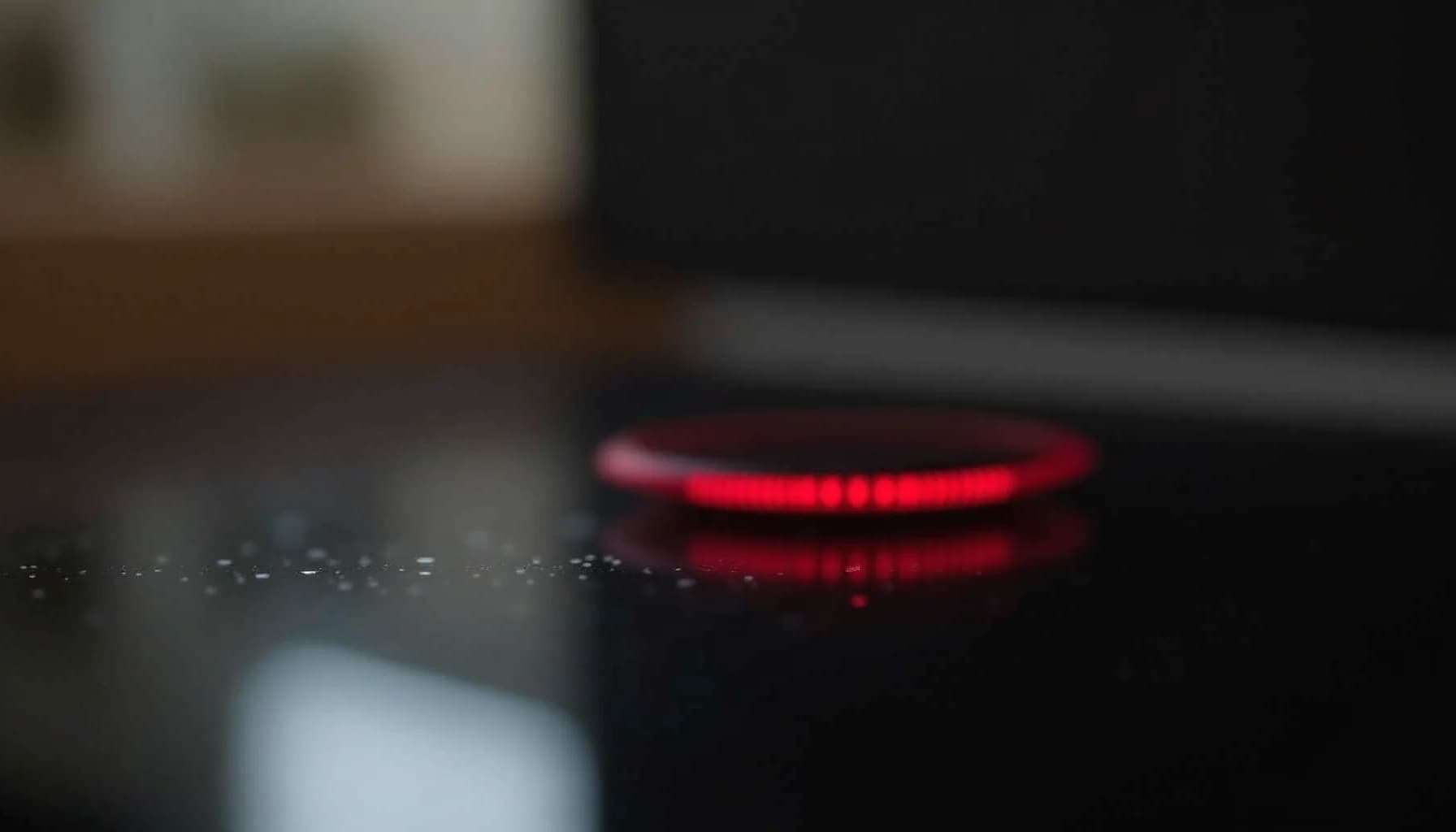 a red glowing electric stove burner on a dark stovetop surface
