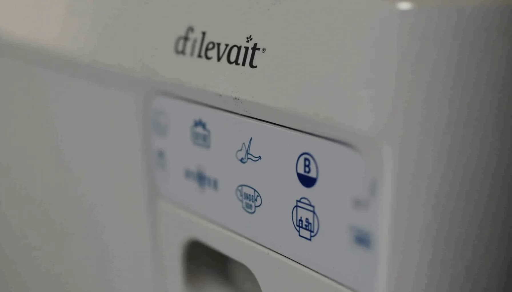 a Levoit air purifier control panel with blue icons and text labels on a white surface