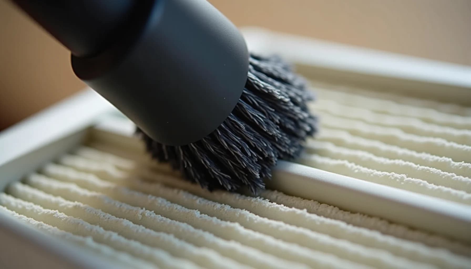 a black-bristled brush cleaning the ribbed white surface of an air purifier filter