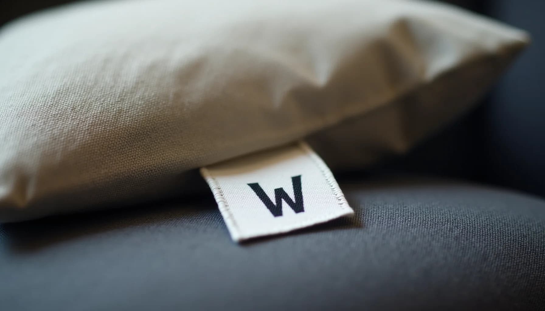 neutral-toned fabric swatches with a white care label marked 'W' on gray upholstery material